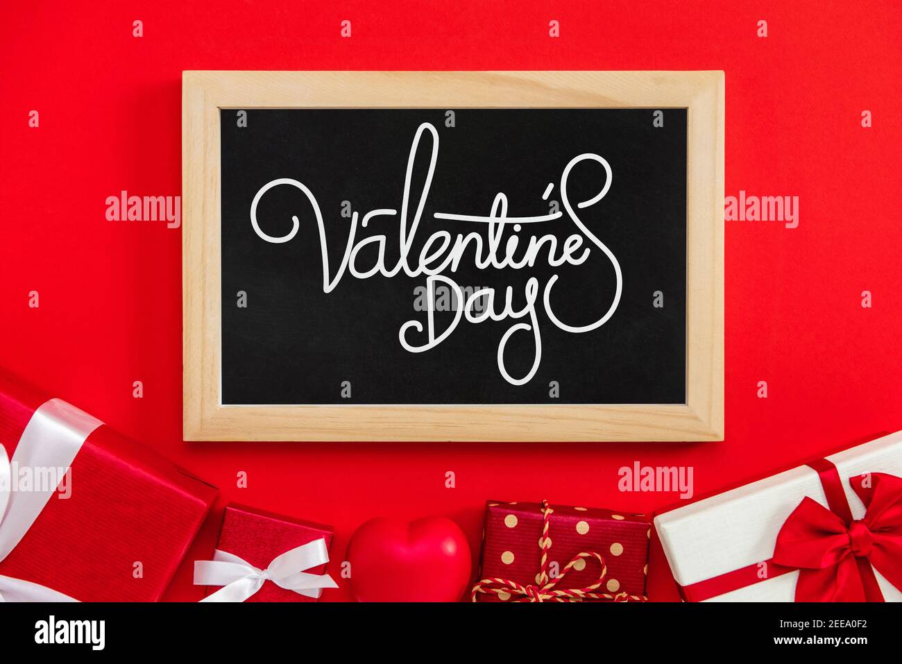 Valentinstag Grußtext in Tafel mit Geschenkschachteln an Roter Hintergrund Stockfoto