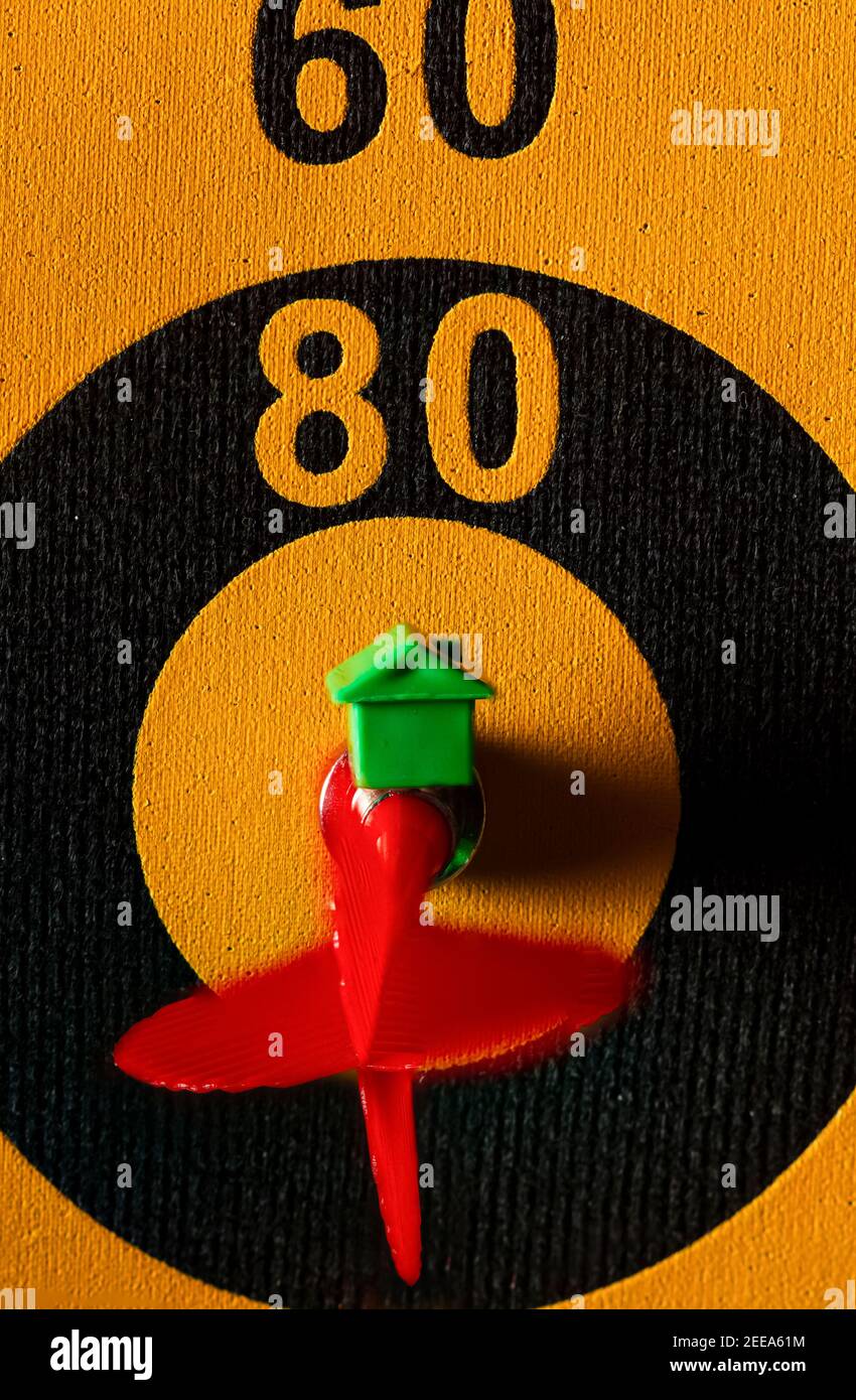 Ein Dartboard mit einem Pfeil, der das Bullseye trifft. Es gibt ein kleines Haus Symbol auf diesem Pfeil. Ein vielseitiges Image für Wettbewerb, Immobilien, Hou Stockfoto