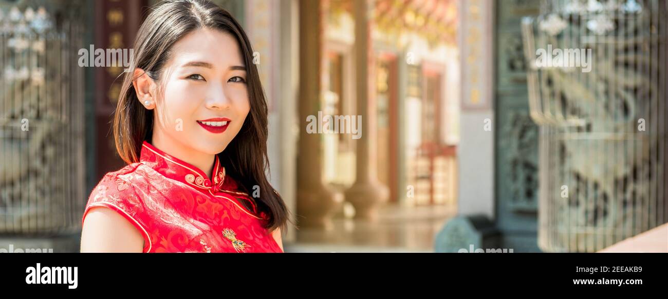 Lächelnd schöne asiatische Frau in traditionellen roten Cheongsam Qipao Kleid in chinesischen Tempel, Panorama-Banner Stockfoto