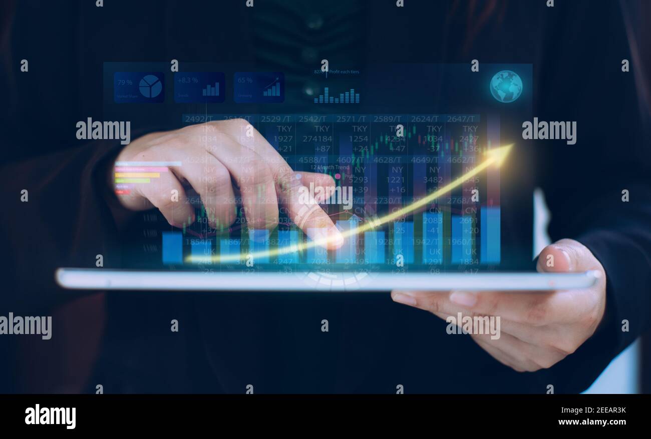 Business Investment Consultant analysiert Finanzbericht eines Unternehmens und arbeitet mit digitalen Augmented-Reality-Grafiken. Stockfoto