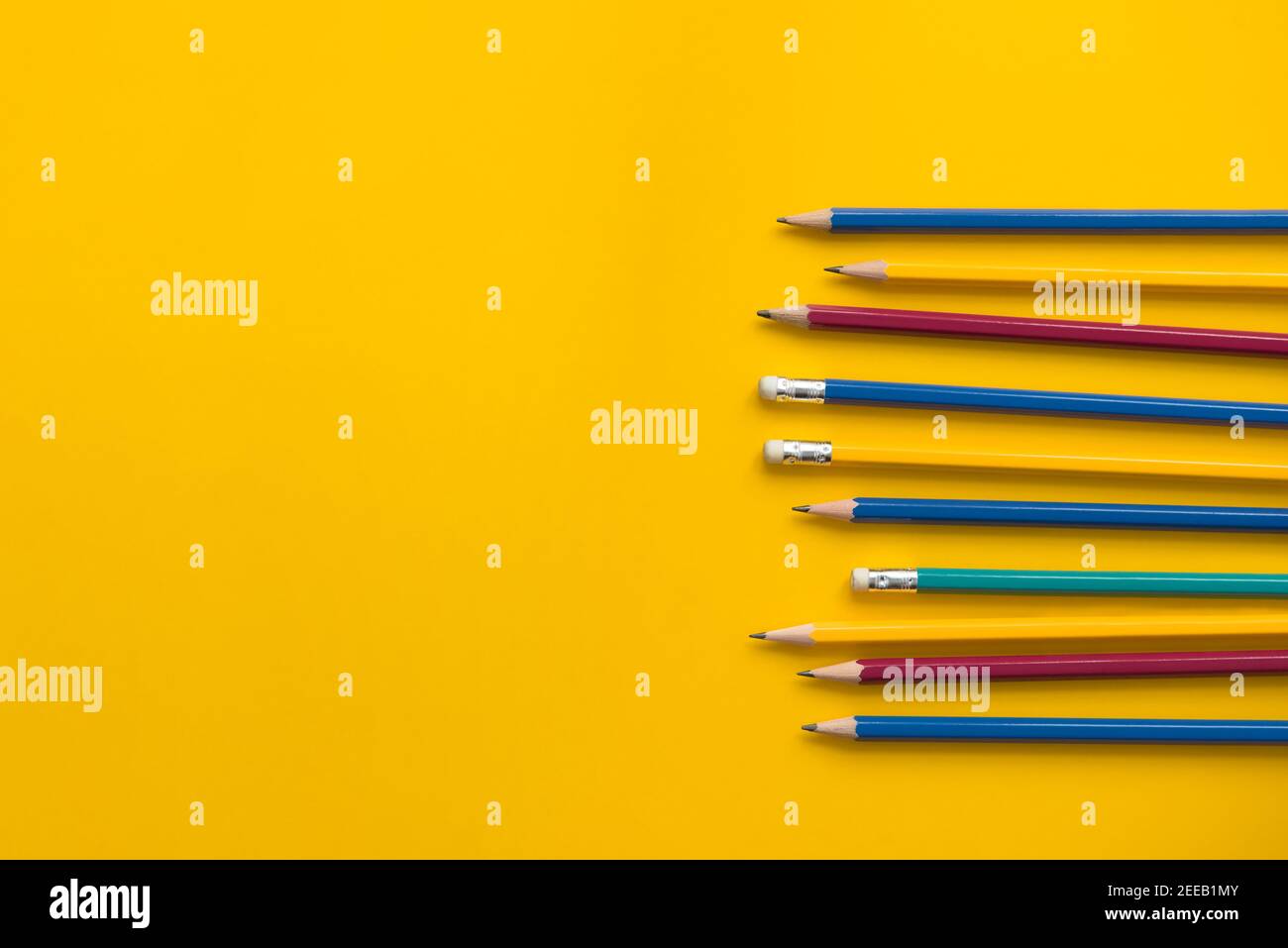 Set von bunten Bleistiften auf gelbem Papier mit Kopierraum, pädagogisches Background-Konzept Stockfoto