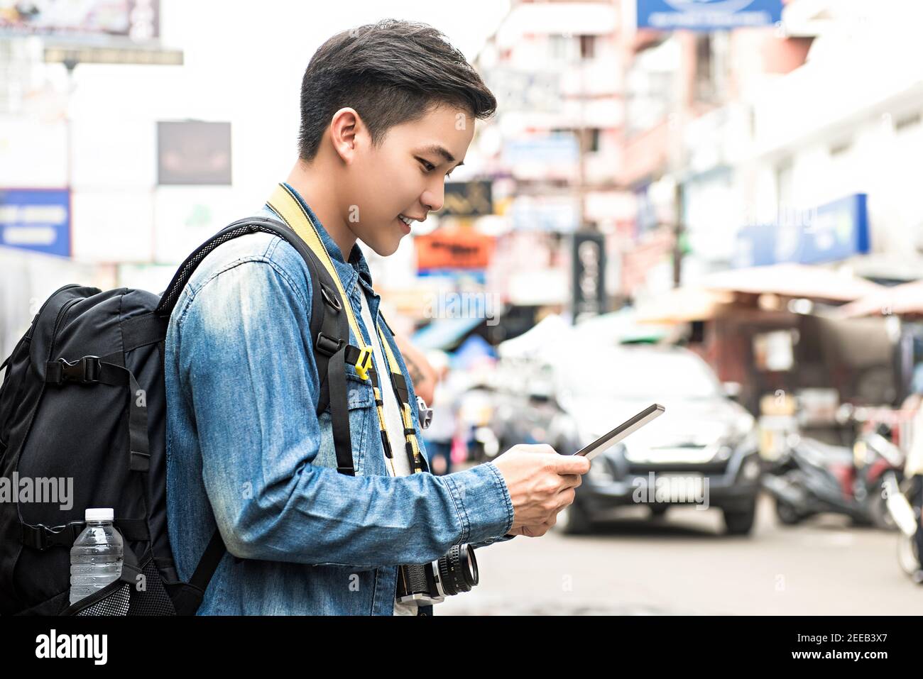 Asiatische Fotograf Tourist Backpacker mit Tablet, um Position zu finden, während Reisen im Urlaub in Khao San Road Thailand Stockfoto