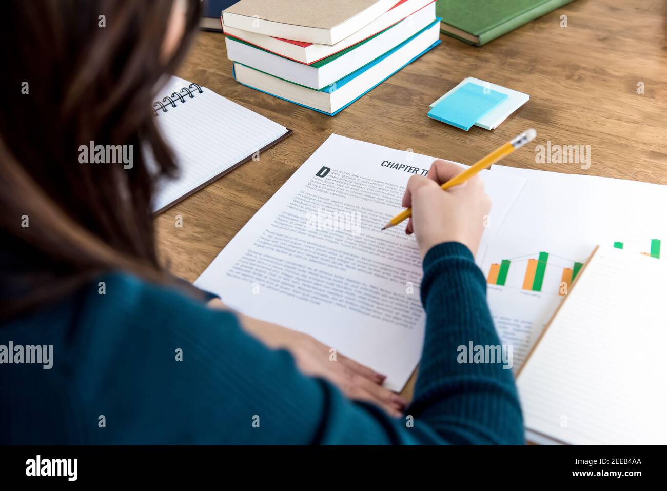 Weibliche College-Student Lesen von Informationen auf Papier Hausaufgaben zu tun Am Tisch Stockfoto