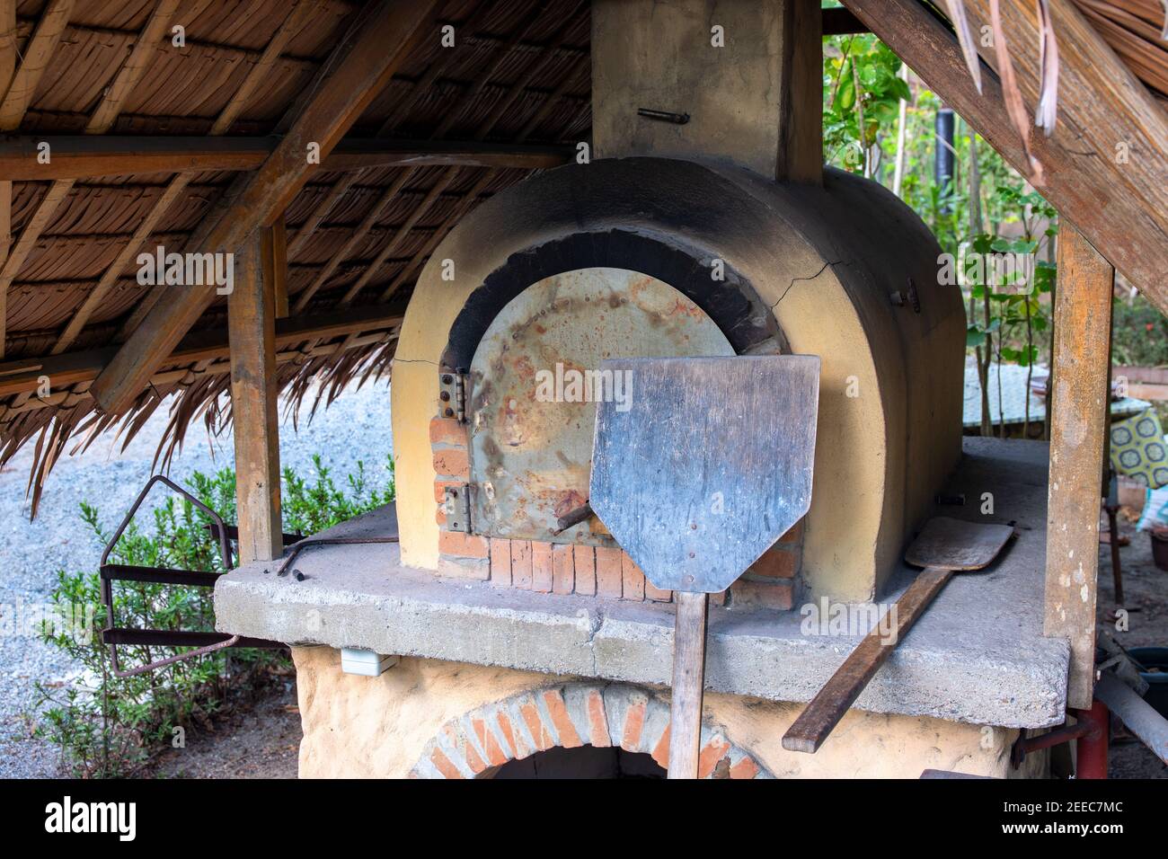 Traditioneller Ofen mit Backwerkzeugen. Pizza und Brot Kochen im Holzofen. Keramik-Steinofen im Vintage-Stil. Ländliche Bäckerei. Authentischer artis Stockfoto