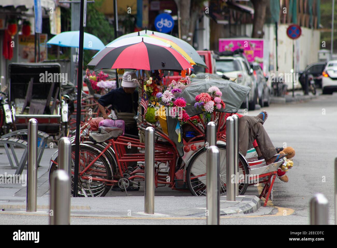 GEORGE TOWN, MALASIA – 31. JANUAR 2020 mehrfarbige Rikschas geparkt und wartet auf Kunden auf der Seite der Straße Stockfoto