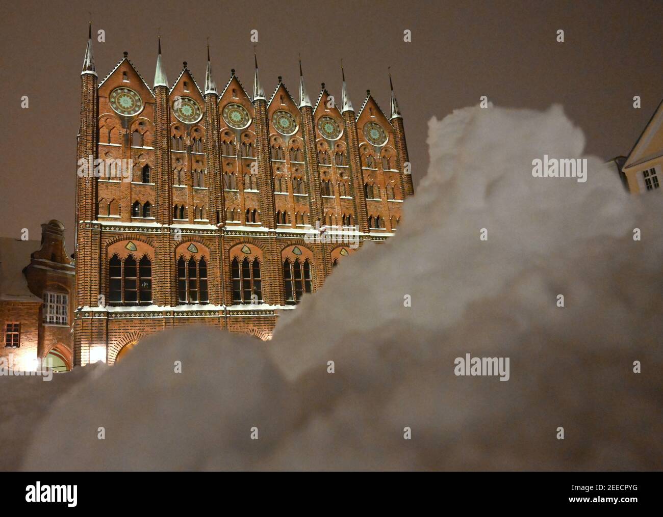 Stralsund, Deutschland. Februar 2021, 16th. Geroderter Schnee liegt am frühen Morgen vor dem Rathaus am Alten Markt im Zentrum von Stralsund. Quelle: Stefan Sauer/dpa-Zentralbild/dpa/Alamy Live News Stockfoto