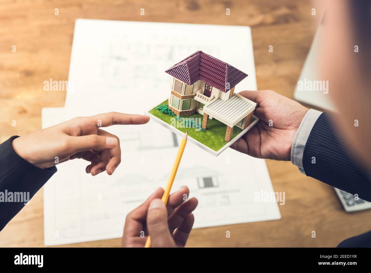 Housing Developer Agent hält ein Architekturmodell und erklärt Konzept für Kunden oder Architekten für die Immobilienentwicklung. Stockfoto