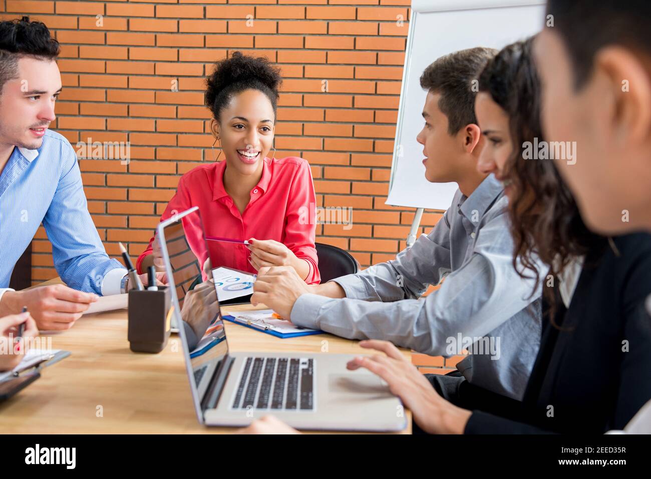 Lächelnd schöne glücklich schwarze Geschäftsfrau Führer in Verkaufsmeeting Mit ihrem Multiethinc-Kollegen-Team Stockfoto