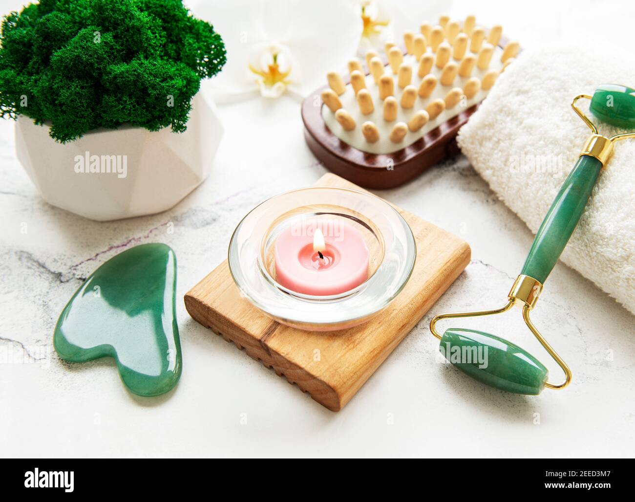 Gesichtsmassage Jade Roller mit kosmetischen Produkt auf weißem Marmor Hintergrund Stockfoto