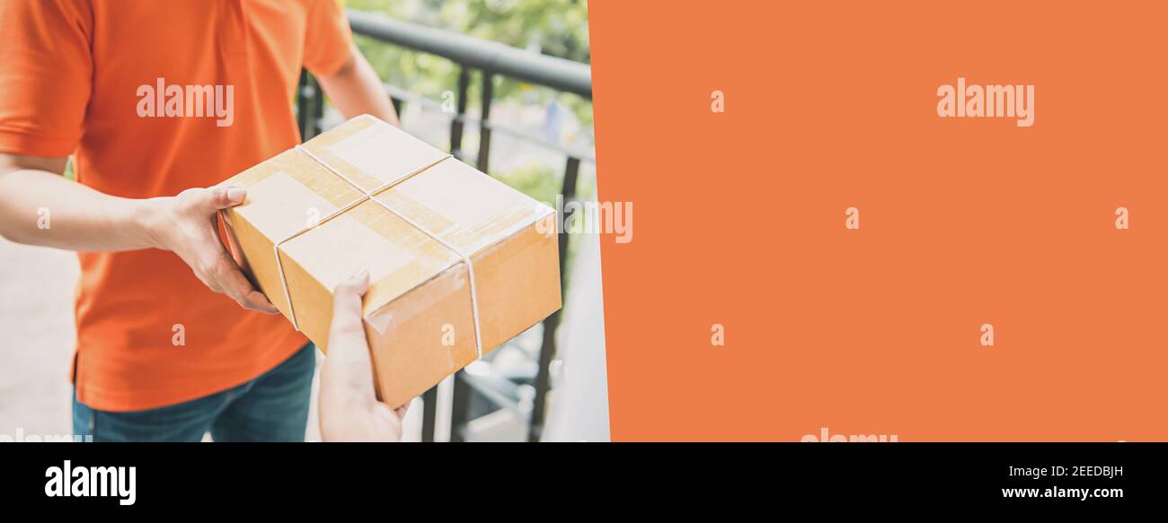 Delivery man in orange Uniform Übergabe eines Paketkastens an einen Kunden, Kurierservice Konzept - horizontaler Webbanner Hintergrund mit Kopierplatz auf Stockfoto