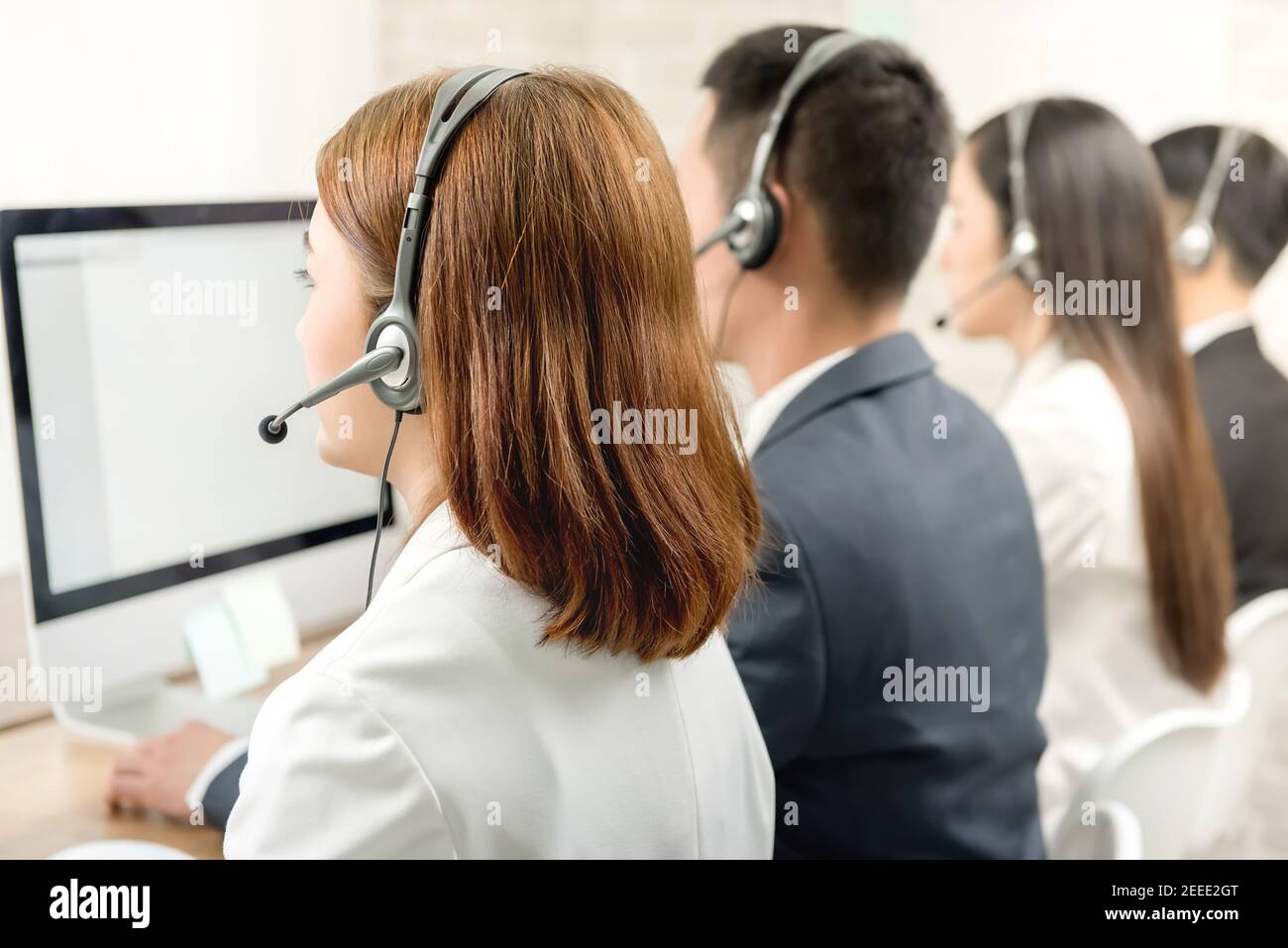 Rückansicht des asiatischen Telemarketing-Kundendienstmitarbeiterteams, Call Center-Jobkonzept Stockfoto