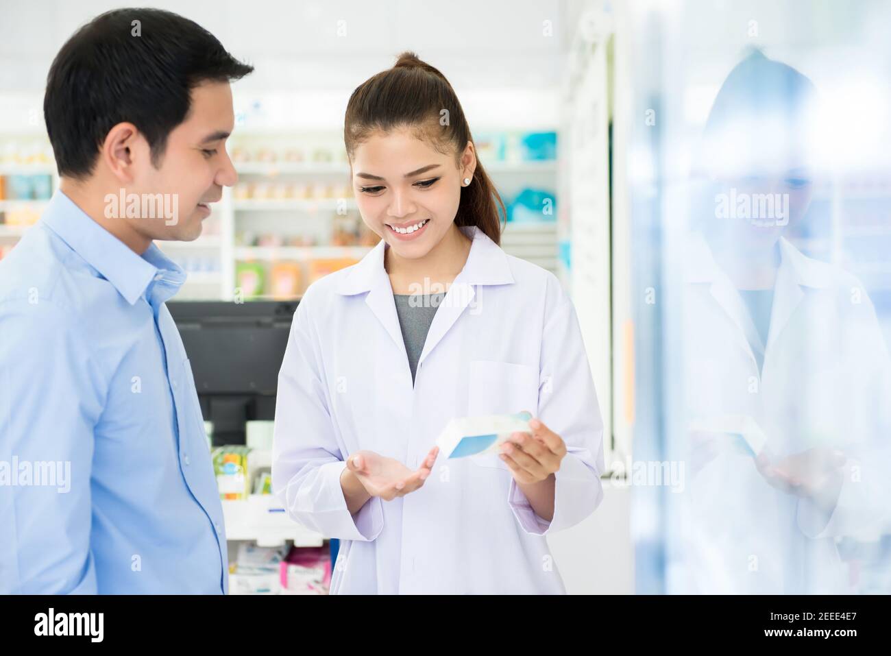 Apothekerin hält Medikamentenflasche geben Beratung für Kunden in Apotheke oder Apotheke Stockfoto