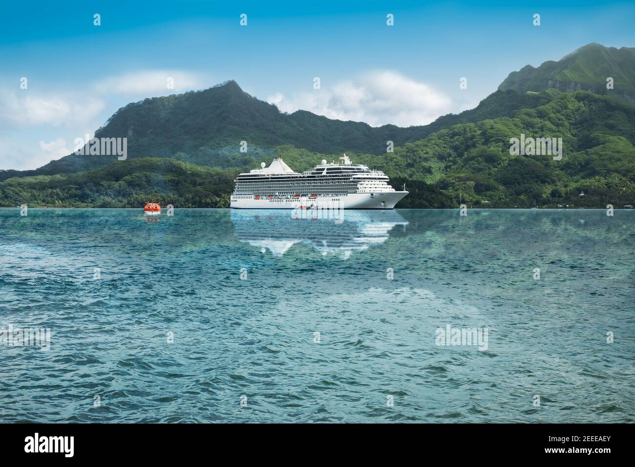 Luxuriöses Kreuzfahrtschiff, das sich in den Gewässern einer wunderschönen Bucht der Leeward-Inseln in Französisch-Polynesien widerspiegelt. Stockfoto