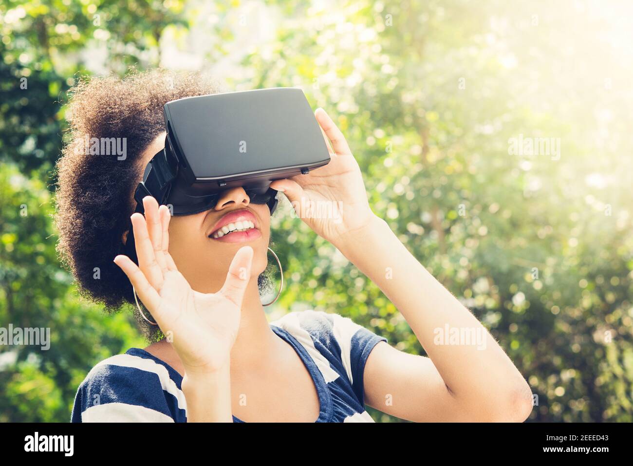 Afro-Frau genießen 3D Simulation Video aus der virtuellen Realität (VR) Headset – Menschen- und Technologiekonzept Stockfoto