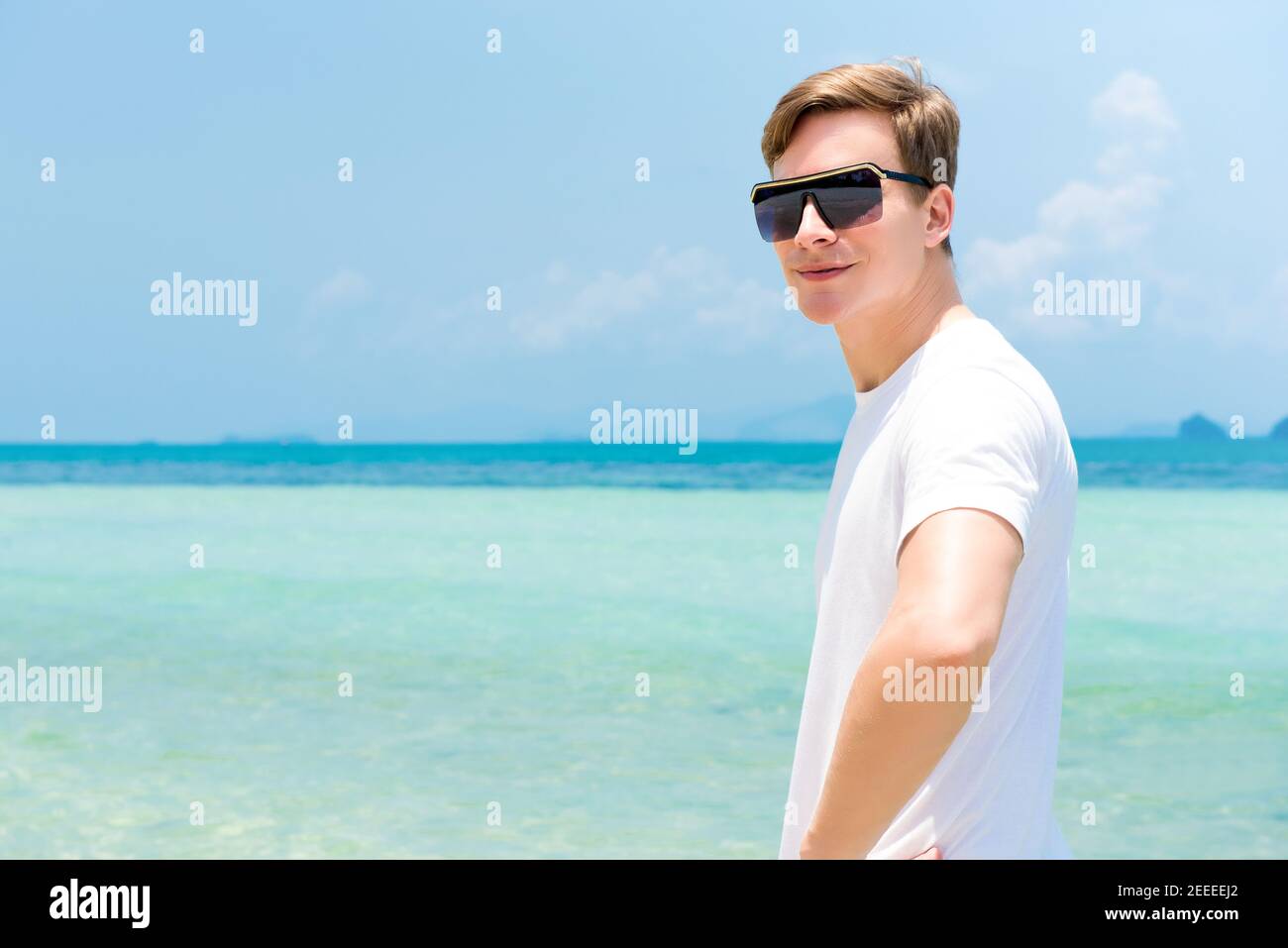 Lächelnder, zwangloser Tourist mit Sonnenbrille am Strand Sommerurlaub Stockfoto Lächelnder, zwangloser Tourist mit Sonnenbrille am Strand Sommerurlaub Stockfoto