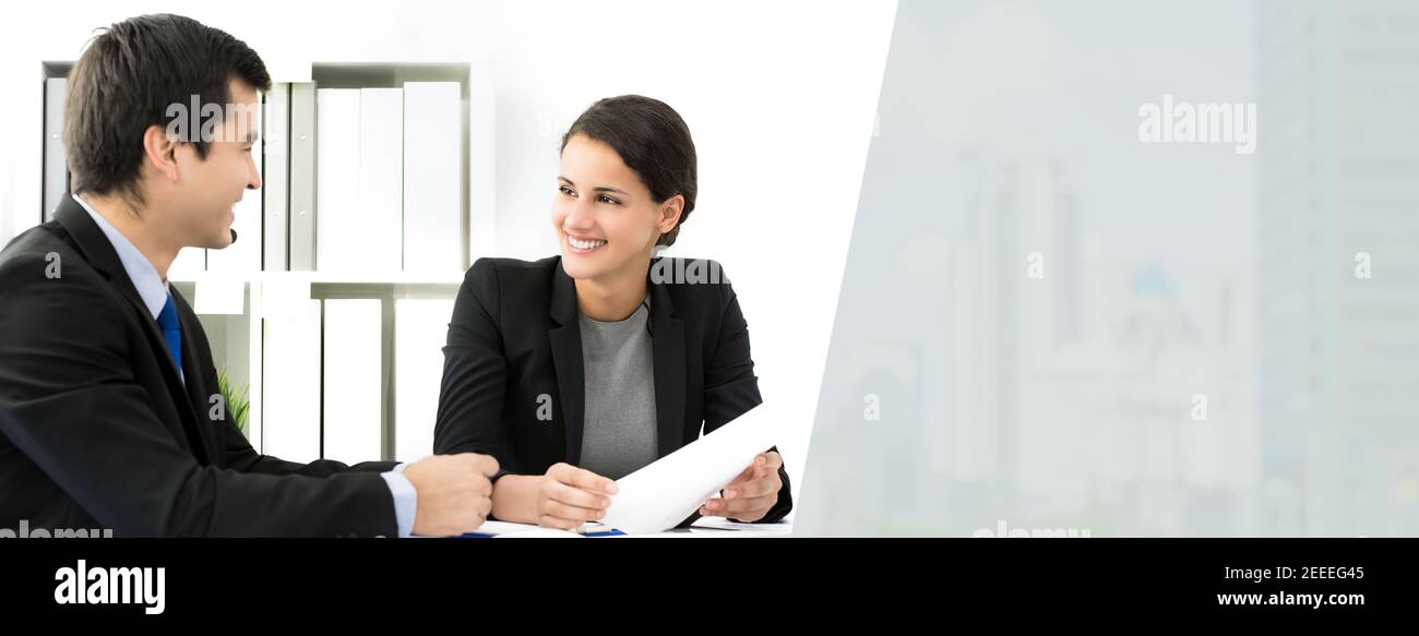 Schöne Geschäftsfrau hört und lächelt zu ihrem Kollegen am Meeting - Panorama-Webbanner mit Kopierbereich Stockfoto