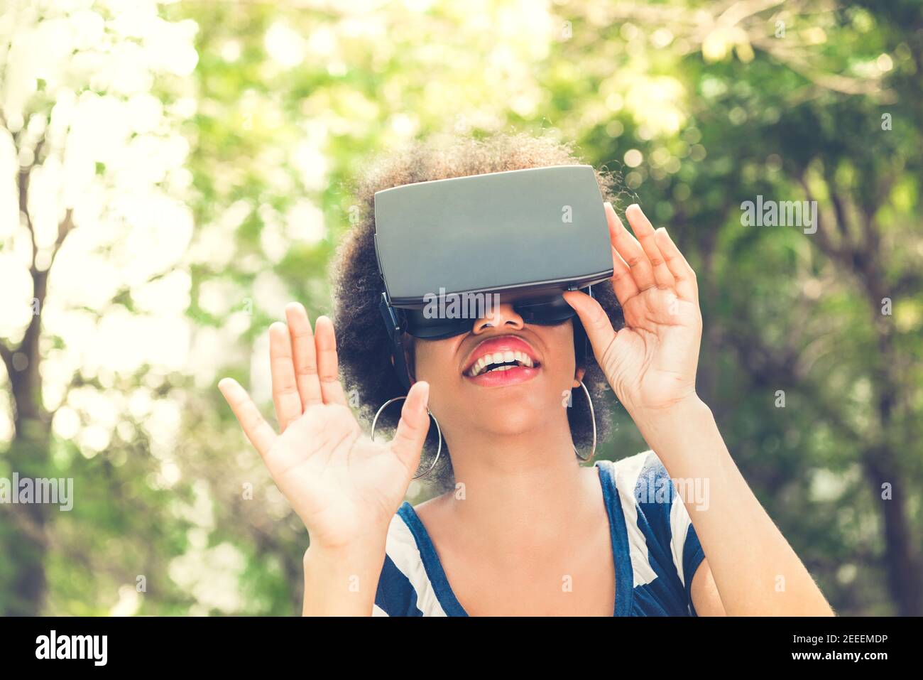 Afro-Frau genießen 3D Simulation Video aus der virtuellen Realität (VR) Headset – Menschen- und Technologiekonzept Stockfoto