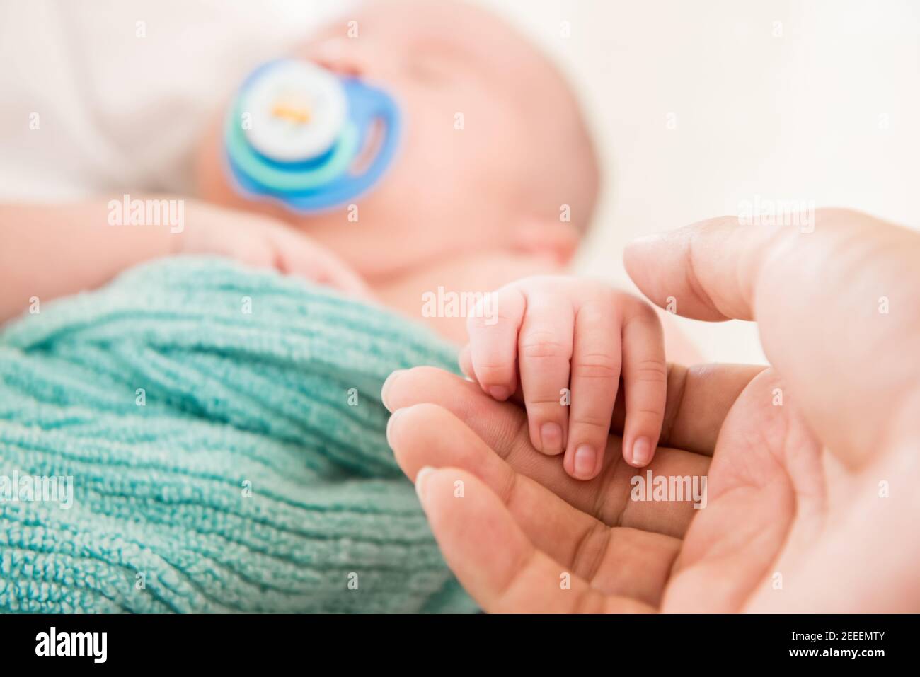 Vater hält Hand von niedlichen Neugeborenen schlafen Baby - Familie Liebe und Bindung Konzepte Stockfoto