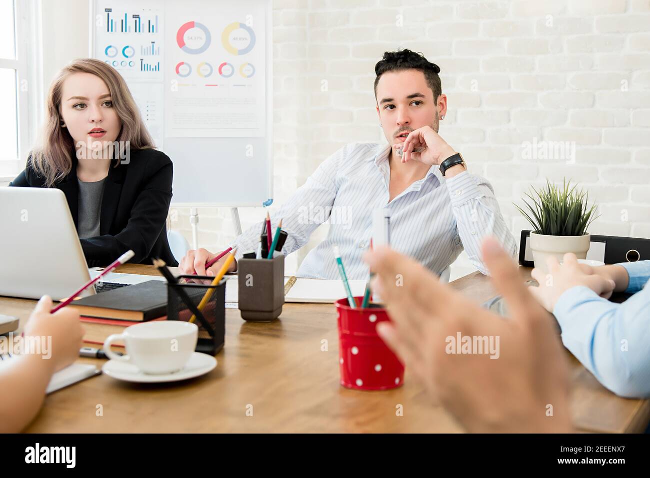 Zwei Geschäftsleute, die bei der Besprechung auf ihre Kollegen achten Im Büro Stockfoto