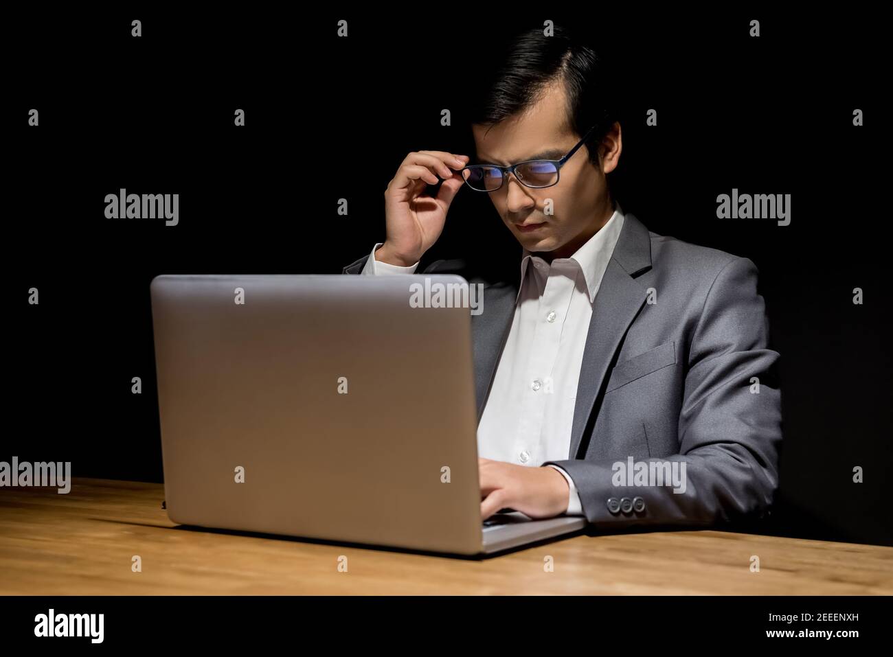 Geschäftsmann mit Laptop-Computer arbeiten spät in der Nacht im Dunkeln Raum - Workaholic und Hacker-Konzept Stockfoto