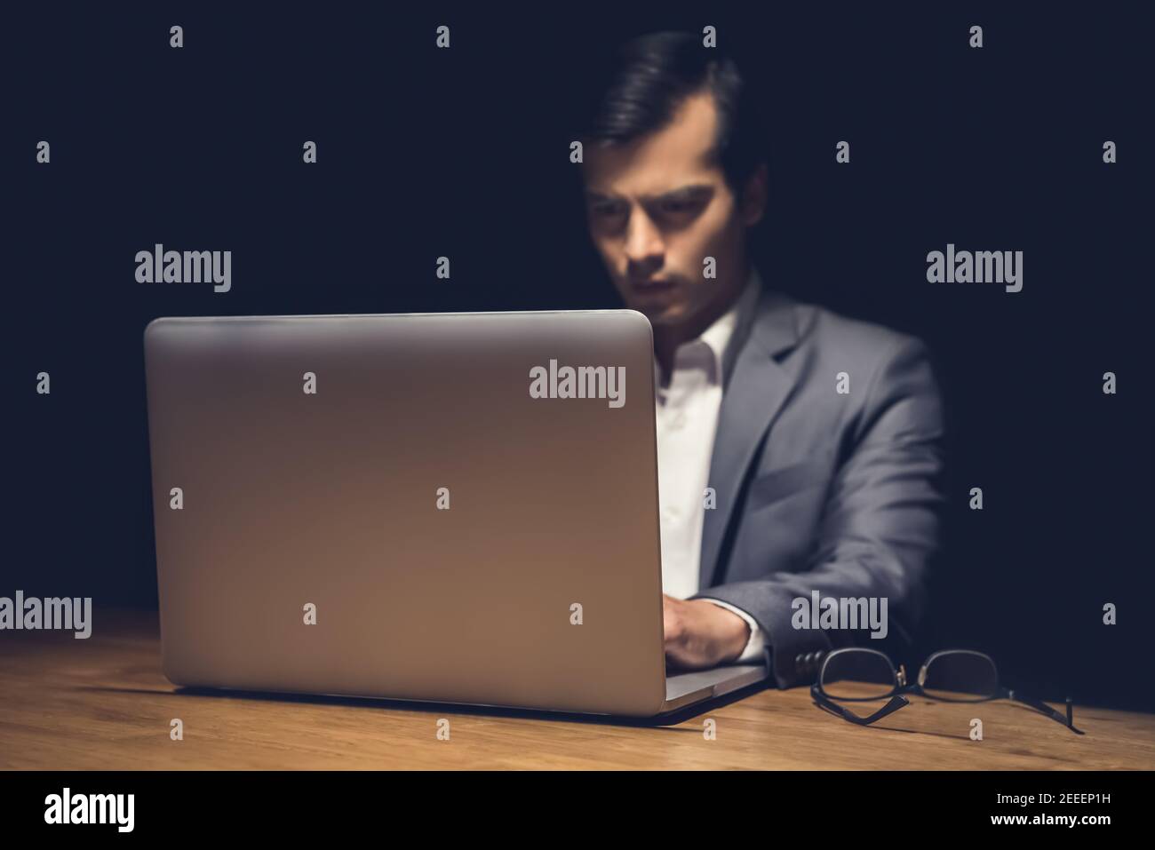 Geschäftsmann mit Laptop-Computer arbeiten spät in der Nacht im Dunkeln Raum - Workaholic und Hacker-Konzept Stockfoto