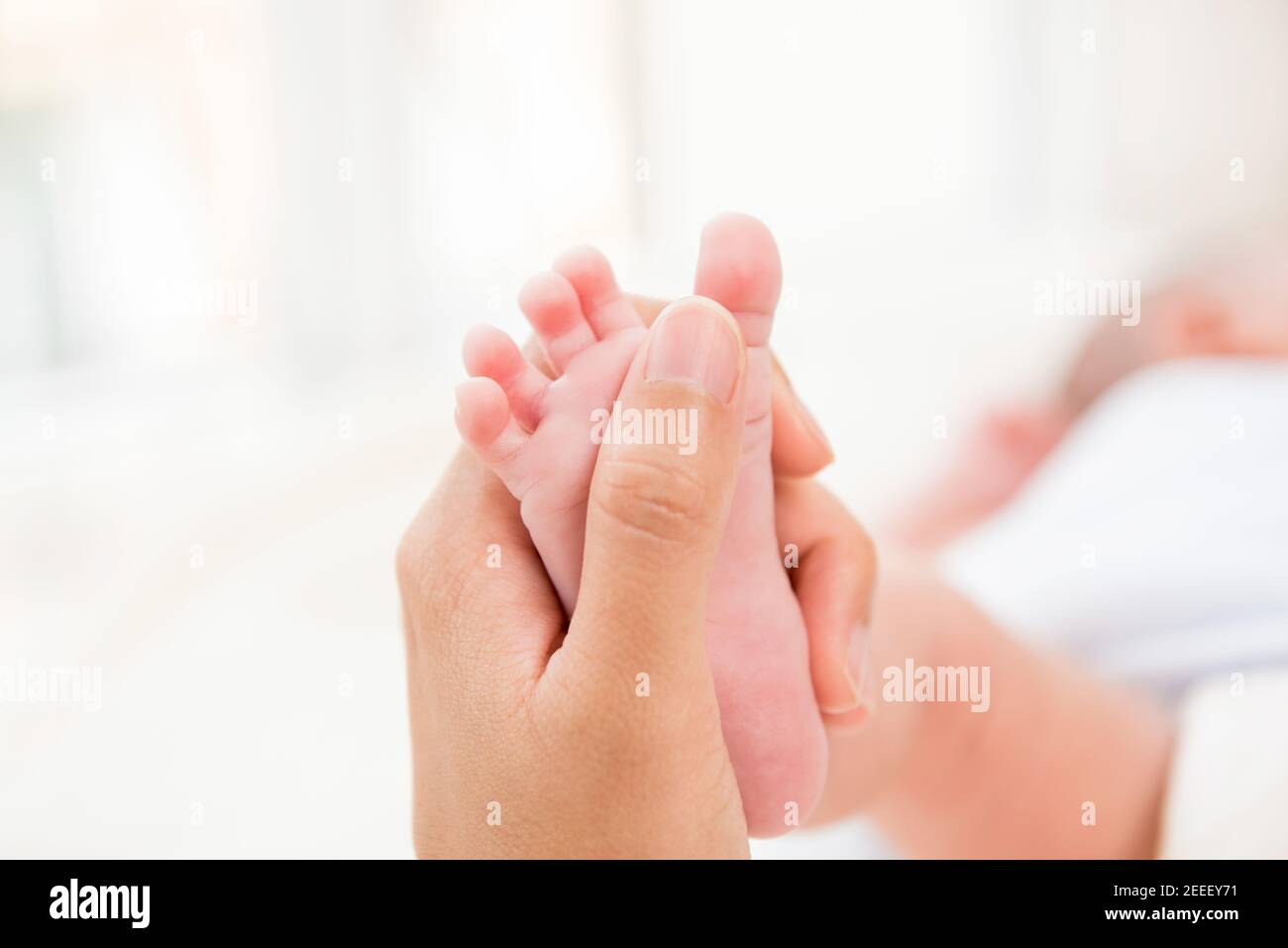 Mutter Hand sanft berühren kleinen Baby Fuß mit Sorgfalt Stockfoto