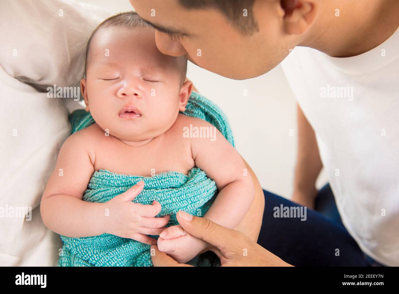 Vater sanft küssen niedlich schlafen neugeborenes Baby mit Liebe und Pflege Stockfoto