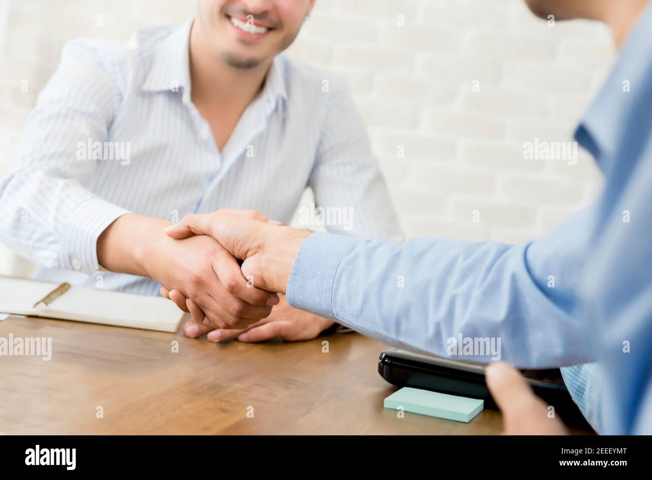 Lächelnd casual Geschäftsmann machen Handshake mit seinem Partner in der Besprechung Stockfoto