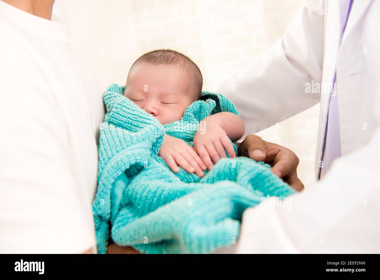 Arzt sanft schlafen Neugeborenes in Vater Arme Stockfoto