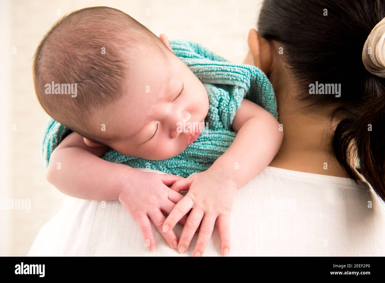 Mutter trägt schlafen liebenswert kleines Baby über der Schulter Stockfoto