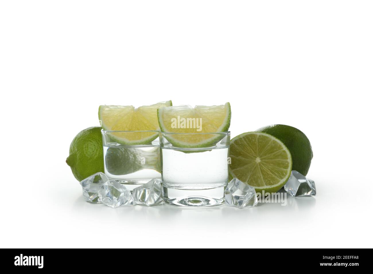 Schüsse von Wodka, Limette und Eiswürfeln isoliert auf weißem Hintergrund Stockfoto