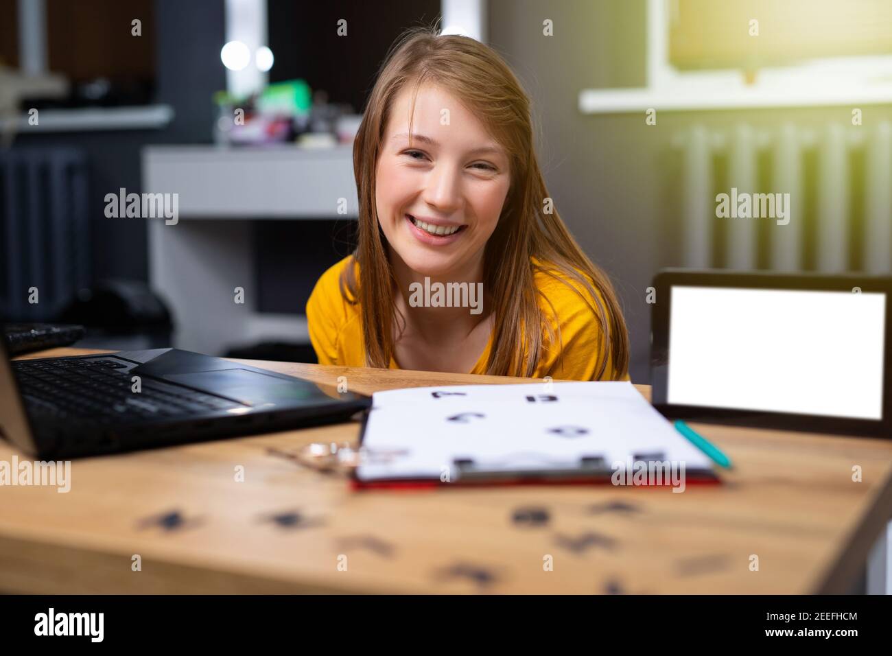 Kaukasischer Lehrer sitzt vor dem Laptop. Englisches Alphabet auf dem Tisch für den praktischen Unterricht mit Schülern. Fernunterricht. Schulbildung zu Hause Stockfoto
