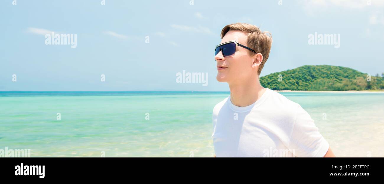Junger Tourist mit Sonnenbrille am Strand Sommer - Panorama-Banner Stockfoto