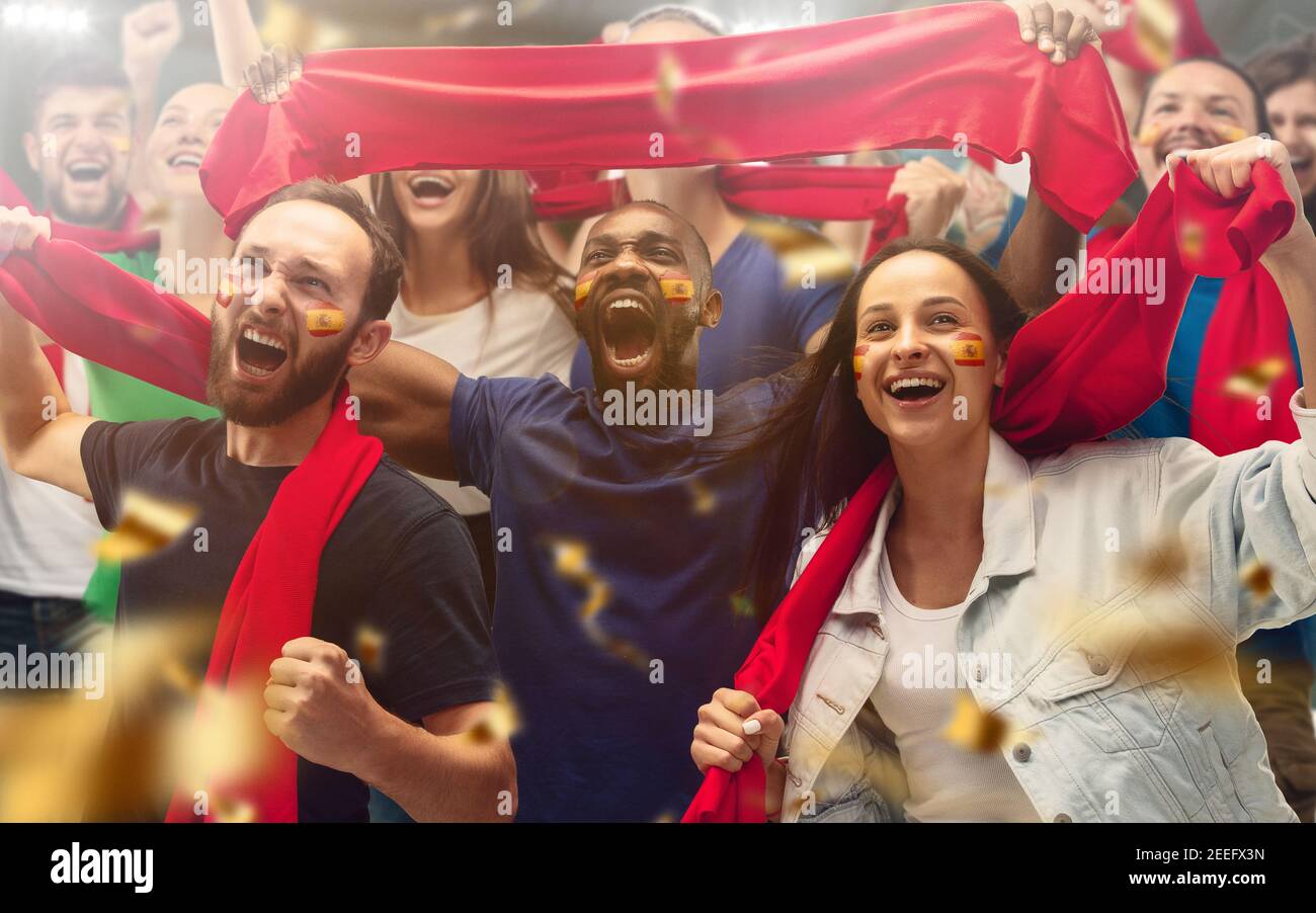 Spanischer Fußball, Fußballfans jubeln ihr Team mit roten Schals im Stadion an. Begeisterte Fans jubeln ein Tor und unterstützen Lieblingsspieler. Konzept von Sport, menschliche Emotionen, Unterhaltung. Stockfoto