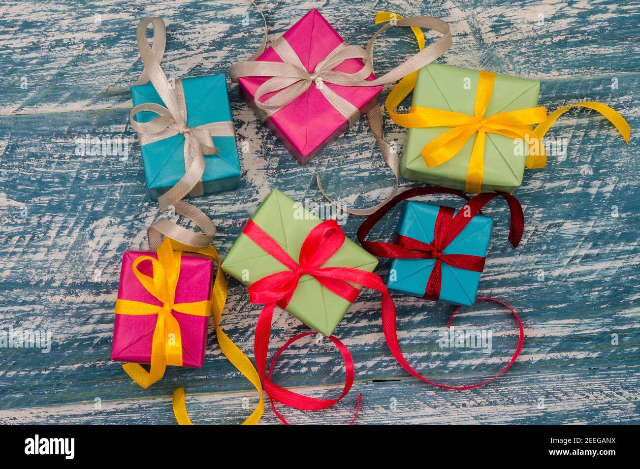 Geschenkboxen mit Origami-Bändern. Blauer türkisfarbener Hintergrund. Fünf Geschenke. Stockfoto