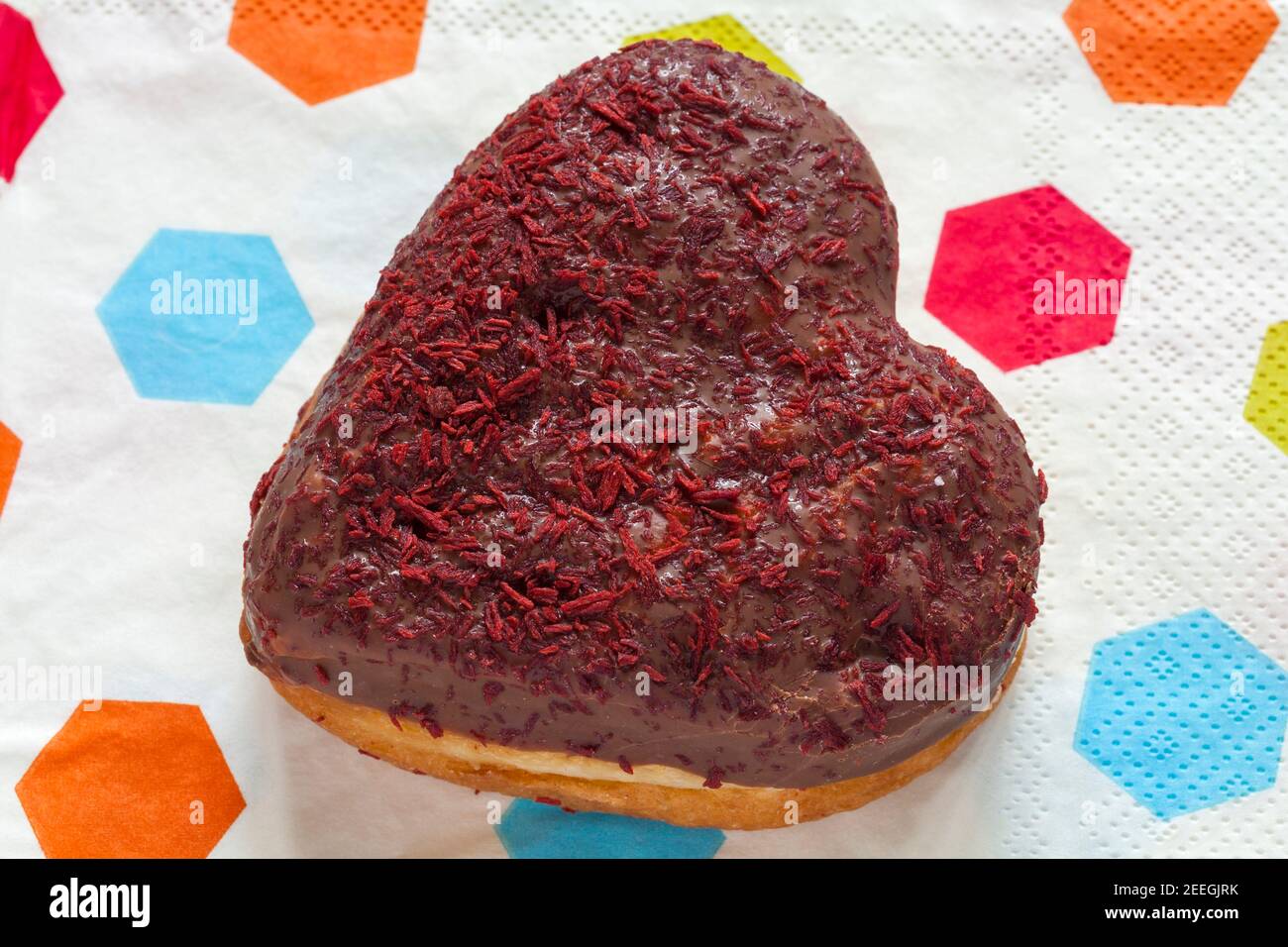 Herzförmiger Donut für den Valentinstag aus der Bäckerei von Marks & Spencer auf Serviettenserviette Stockfoto