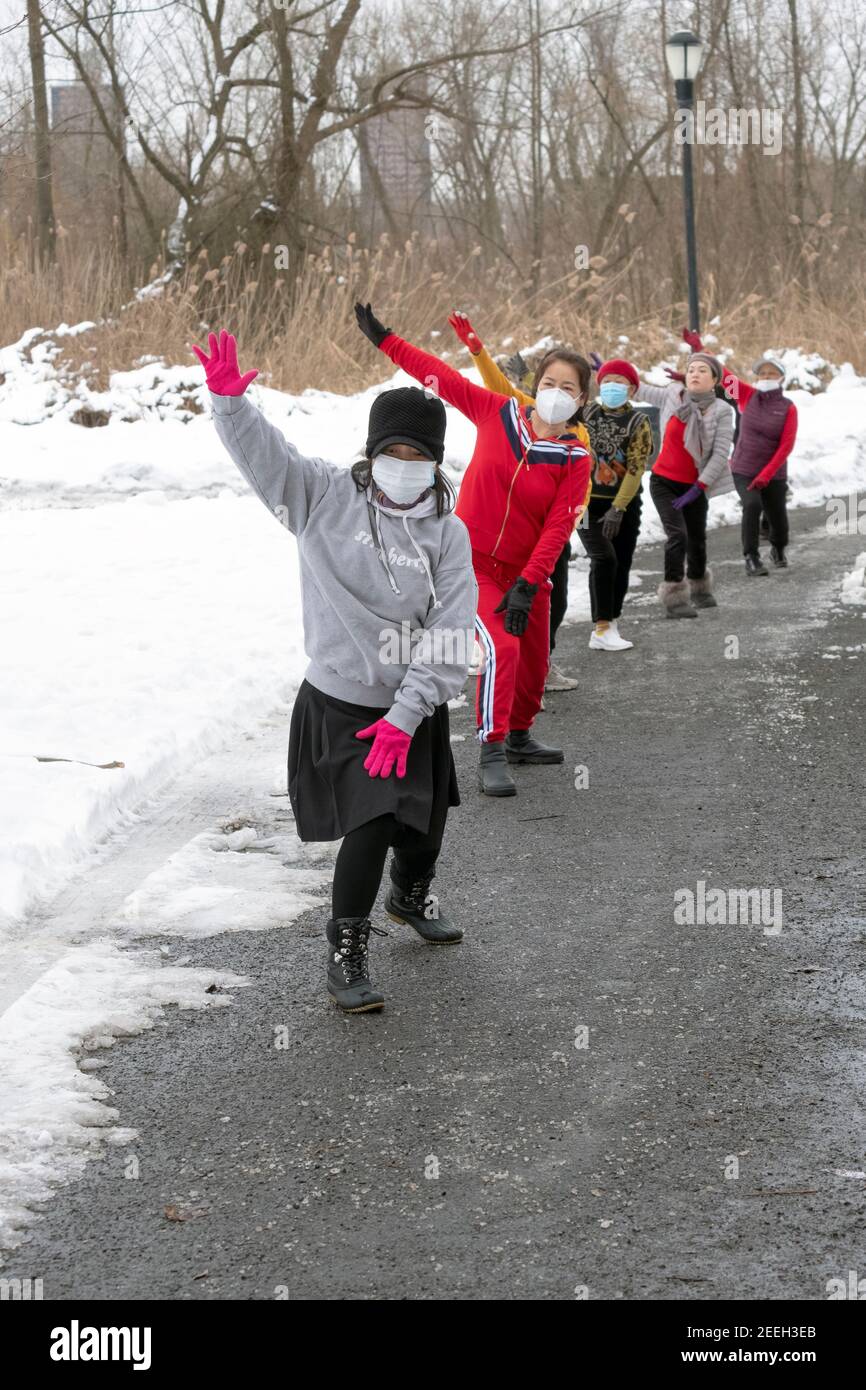 An einem kalten Wintermorgen besuchen asiatisch-amerikanische Frauen, hauptsächlich Chinesen, einen Tanzkurs in einem Park in Flushing, Queens, New York City. Stockfoto