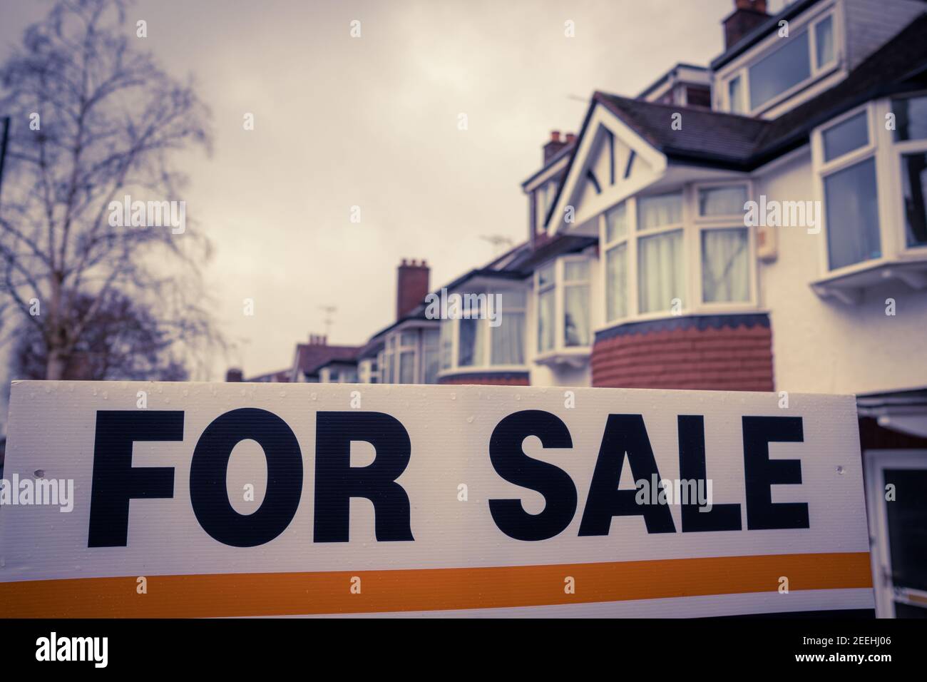 Immobilienmakler "zum Verkauf" Zeichen auf der Straße der Terrassen Häuser Stockfoto
