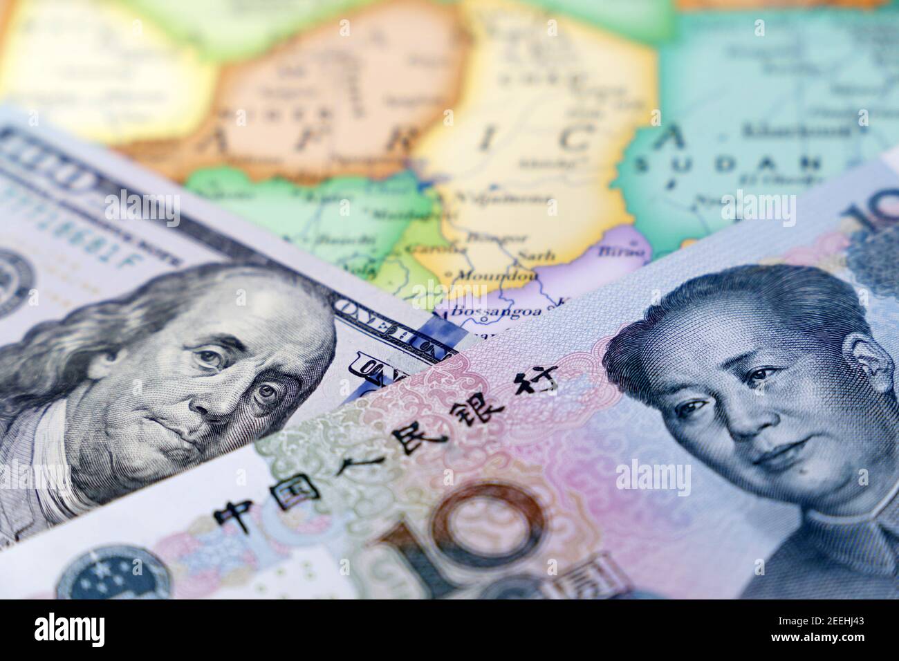 US-Dollar und chinesischer Yuan auf der Karte von Afrika. Rivalität zwischen den USA und China auf dem afrikanischen Kontinent, amerikanische und chinesische Investitionen, Kreditvergabe Stockfoto