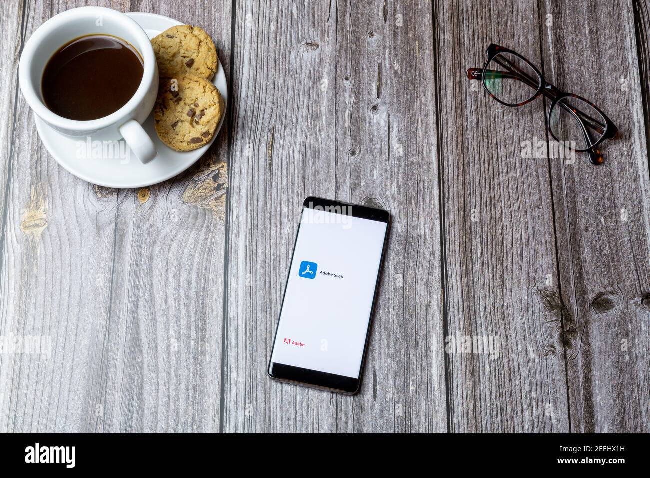 Ein Handy oder Handy auf einem Holz gelegt Tabelle mit der geöffneten Adobe Scan-App auf dem Bildschirm Stockfoto