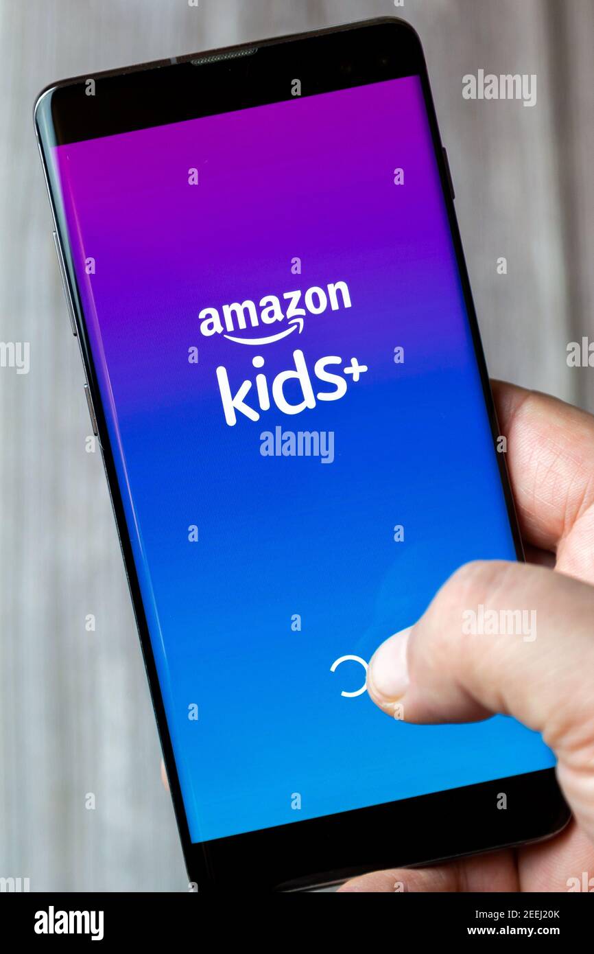 Ein Mobiltelefon oder Mobiltelefon, das in einem gehalten wird Hand mit der amazon Kinder plus App auf dem Bildschirm geöffnet Stockfoto
