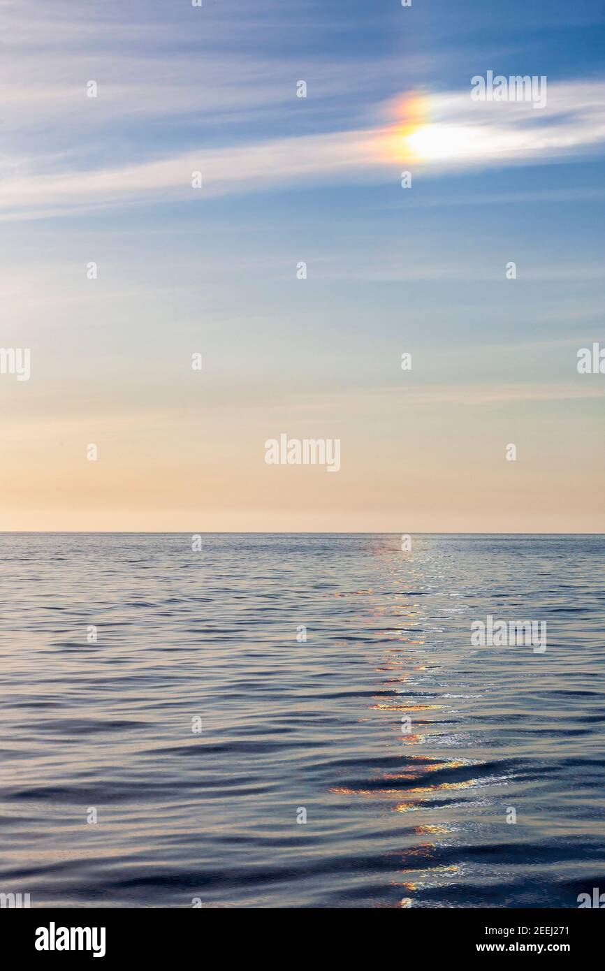 Halo mit Sonnenhund und bunten Reflexen im Meer Stockfoto