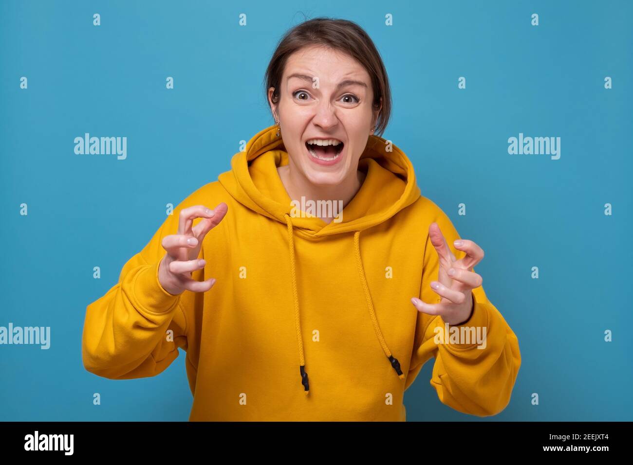 Junge wütende Frau schreiend zusammenklammernden Fingern. Studioaufnahme Stockfoto