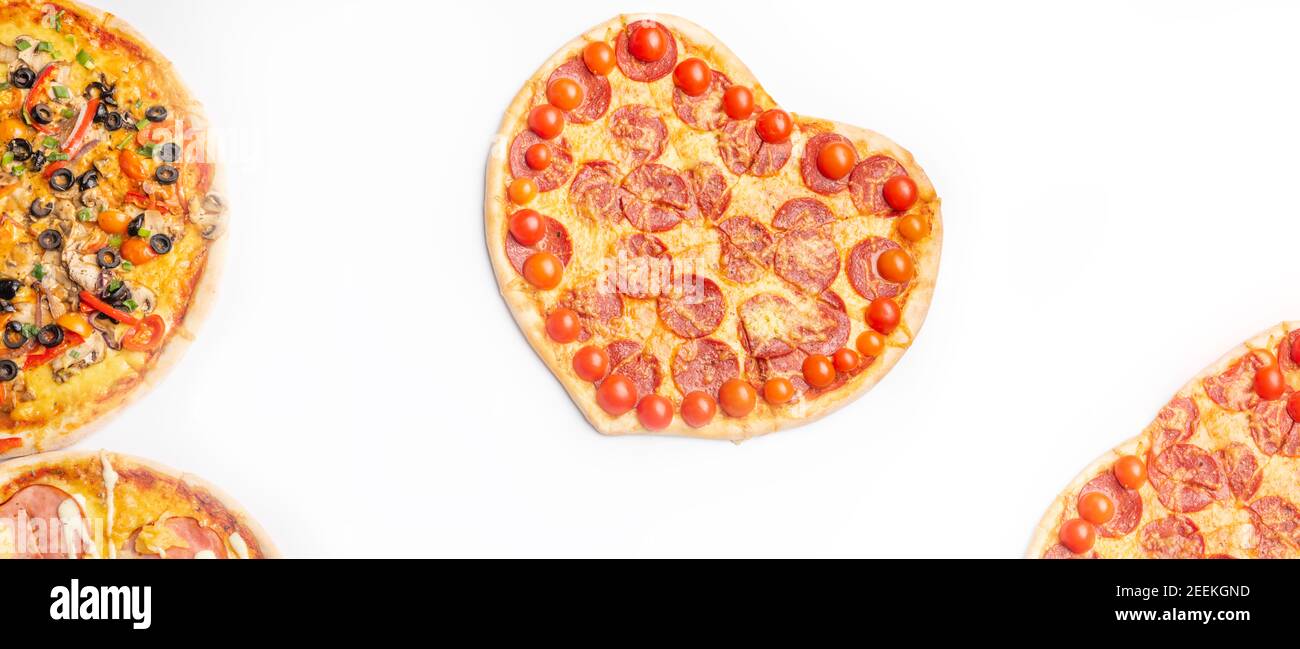 Drei verschiedene Arten von Pizzen, rund und Herz auf weißem Hintergrund mit Kopierraum, Salami, Pilze, Tomaton, Pepperoni, Kirschtomate und Stockfoto