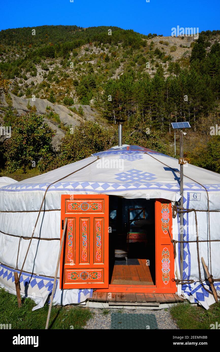 Außenansicht und Eingang des mongolischen Jurten-, Ger- oder Rundzeltes mit bemalter orangefarbener Holztür mit Solarpanel in französischen Alpen Frankreich Stockfoto
