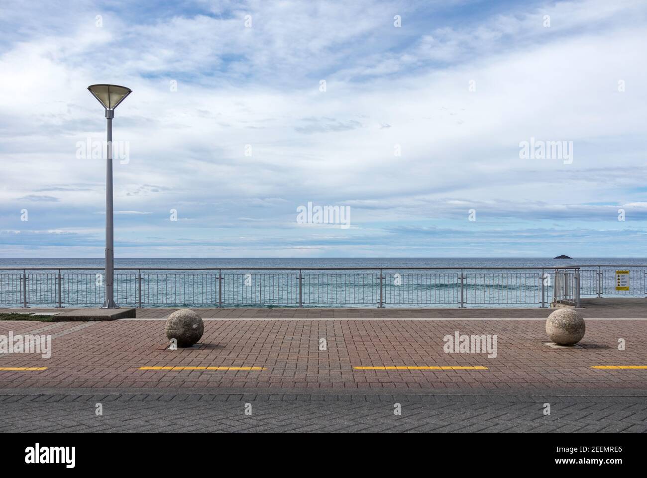 Esplanade in St. Clair, Dunedin, Neuseeland mit einem einzigen Laternenpfosten und 2 kugelförmigen Betonpfosten vor dem Hintergrund von Meer und blauem Himmel, Copyspace Stockfoto