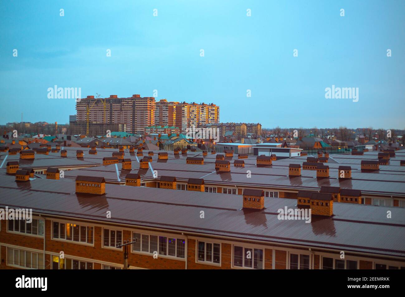 Am frühen Morgen in der Stadt. Schöne Aussicht auf die Dächer bei Sonnenaufgang. Stadtlandschaft. Stockfoto