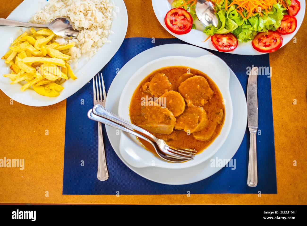 Traditionelles Essen aus Alentejo - Kuhzunge in einer Sauce serviert mit Salat, Reis und pommes frites, Portugal, Europa Stockfoto