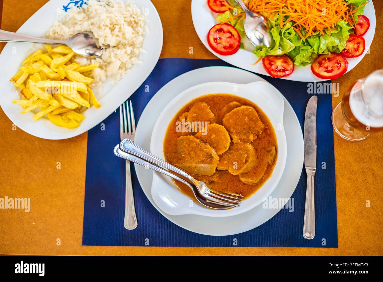Traditionelles Essen aus Alentejo - Kuhzunge in einer Sauce serviert mit Salat, Reis und pommes frites, Portugal, Europa Stockfoto