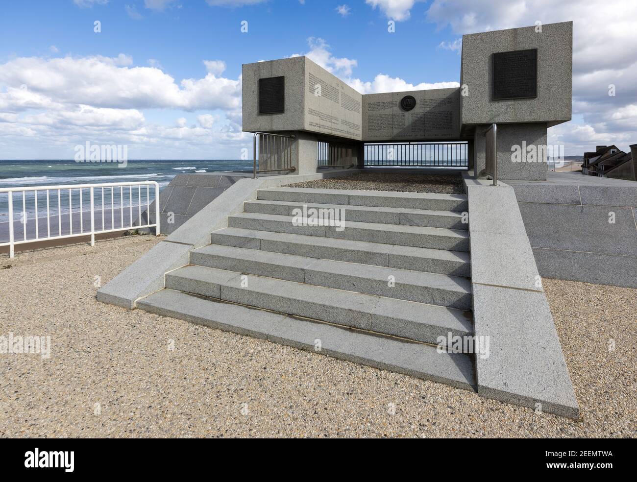 Eine weite Perspektive des WWL-WWll Memorial, Omaha Beach, Normandie, zeigt lesbaren Text in den festen Granit, blauen Himmel, weiße Wolke und Meer graviert Stockfoto